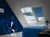 Man in blauw overhemd met das wijst naar raam met blauwe luiken