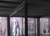 Paarse verticale lamelgordijnen voor drie grote raampartijen in winkel of showroom