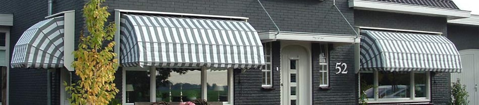 Wit-grijze buitenmarkiezen gemonteerd boven de ingang en ramen van een huis
