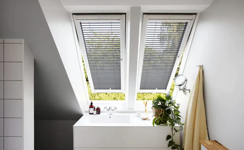 Horizontale jaloezieën voorzien van zonwering in een badkamer met wastafel en plant