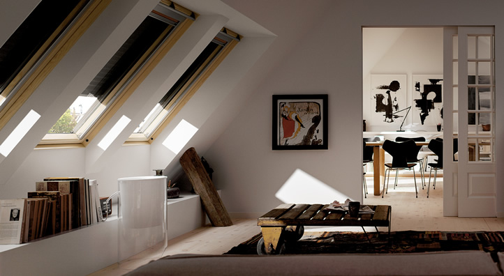Zolderruimte met drie Velux dakramen en houten vloer, met zicht op een woonkamer