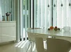 Wit eettafel met stoelen en hanglampen voorvenster met lamelgordijn