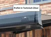 Zwarte Sunmaster knikarmscherm met technisch zilveren profiel gemonteerd aan een houten gevel