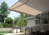 Beige semi-cassette zonnewering gemonteerd boven een terras met planten