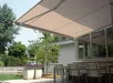Semi-cassette zonwering boven een terras met buitenmeubels en planten