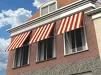 Rode en witte gestreepte uitvalschermen aan gevel