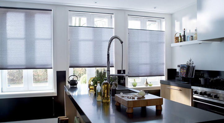Moderne keuken met horizontale rolgordijnen voor het raam en een eiland met kraan en kruidenflesjes