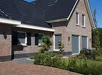 Donkerbruin uitvalscherm gemonteerd aan de gevel van een vrijstaande woning