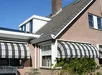 Witte aluminium zonwering met lamellen voor een raam