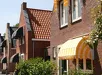 Aluminium zonwering met lamellen aan een roodstenen huis