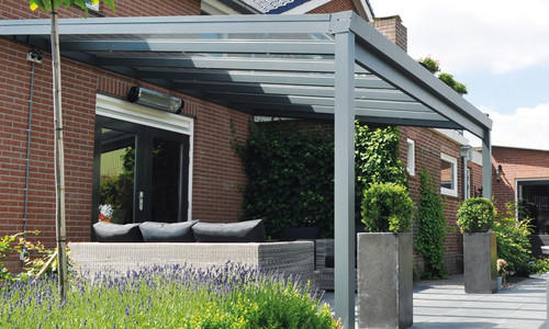 Budget terrasoverkapping met zitbank en planten voor een bakstenen huis