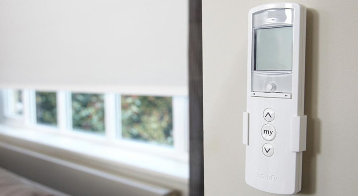 Witte Somfy bedieningspaneel met knoppen en display gemonteerd aan de muur