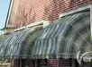 Grote aluminium zonwering gemonteerd aan de gevel van een huis