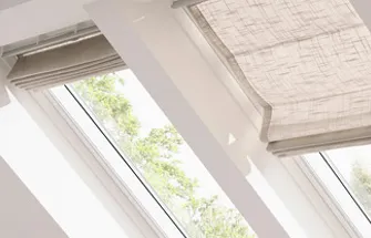 Rood Velux-logo op een houten achtergrond bij een raam