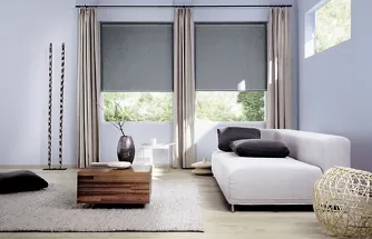 Grijze horizontale zonwering tussen twee ramen in een moderne woonkamer met witte bank en houten tafel