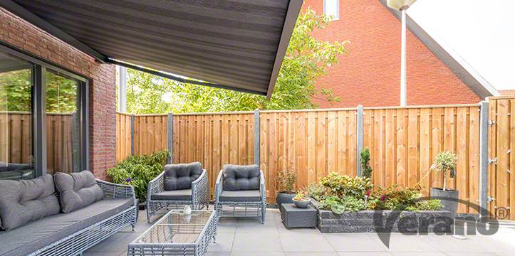 Zonwering op schuifdeuren in tuin met houten schutting, meubels en planten