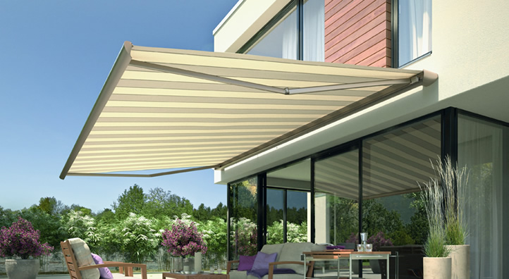 Knikarmscherm in beige gekleurd boven een terras met tuinmeubilair en planten