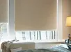 Slaapkamer met lichtbeige rolgordijn en nachtkastje met lamp