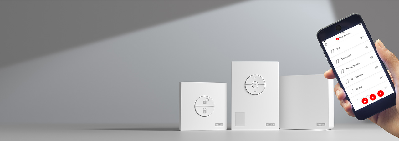 Drie Velux bedieningspanelen met verschillende functies en een smartphone met app voor afstandsbediening