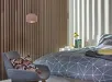 Gordijn met donkere lamellen naast bed met geometrisch beddengoed