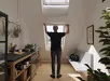 Man op een trap die een insectenhor bij een raam plaatst