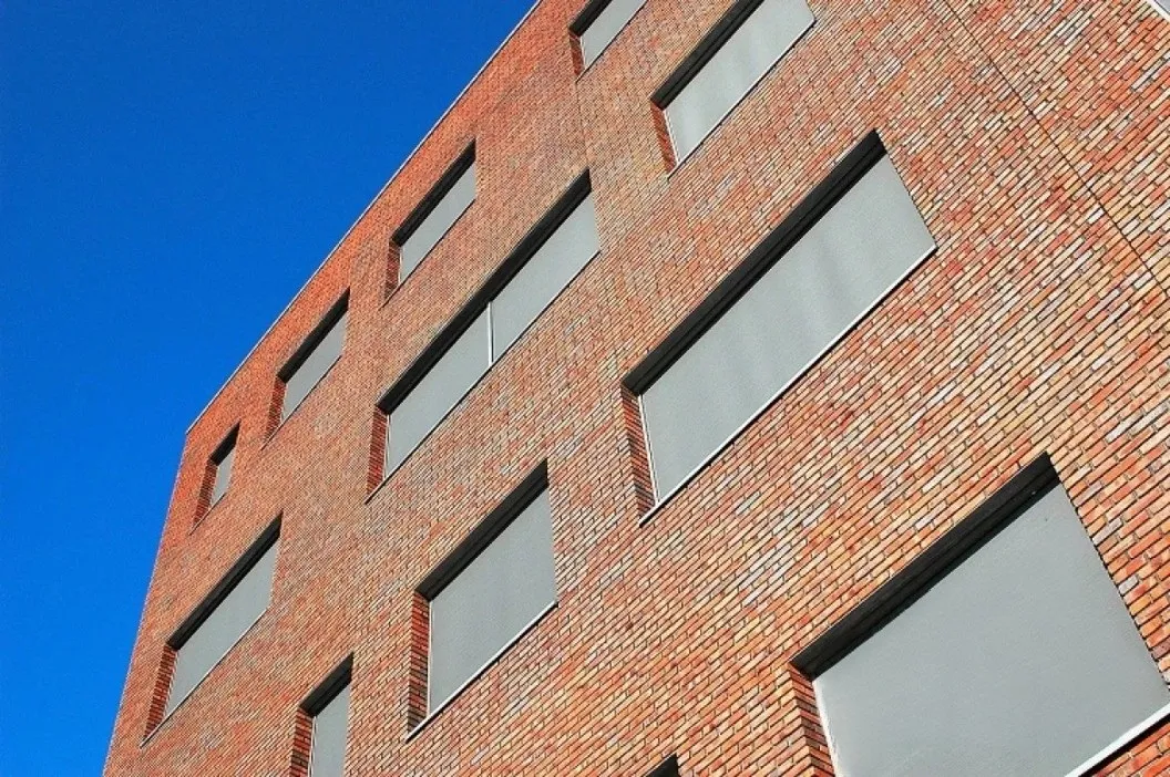 Gebouw met horizontale zonweringsschermen op de ramen