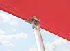 Bedieningsstok van Fakro zonwering bevestigd aan het rood gordijn met metalen klem