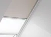VELUX duo-rolgordijn in lichtroze en wit, half open in dakraam