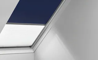 VELUX duo-rolgordijn in donkerblauw en wit, half open in dakraam