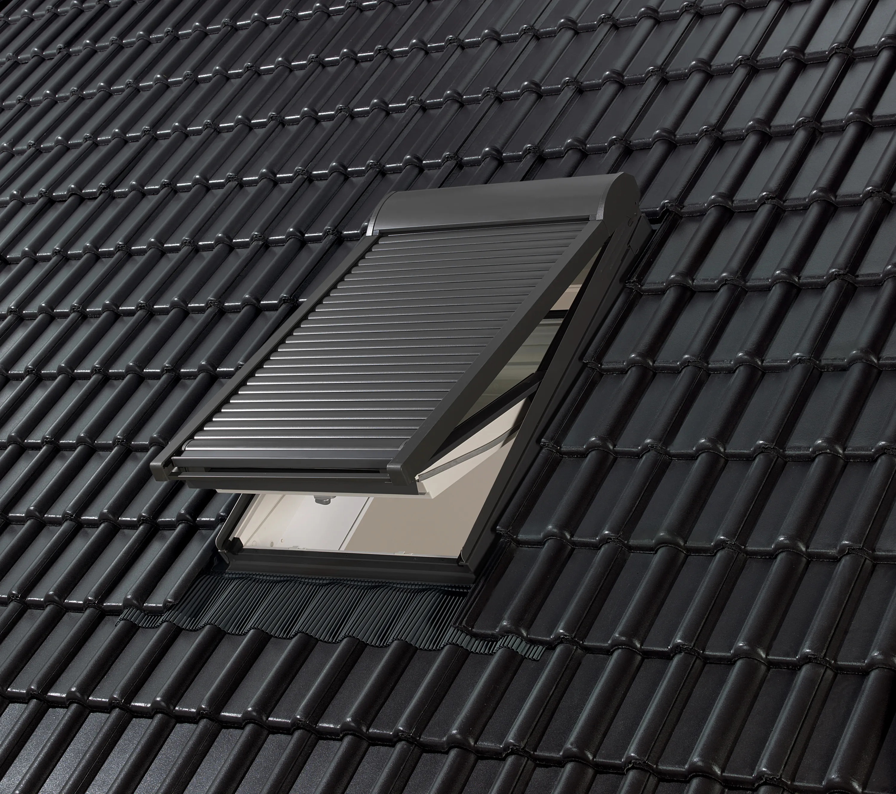 Handbediend VELUX rolluik in dakpannen op een hellend dak