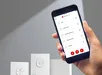 Hand houdt smartphone met VElux Active app voor zonweringbediening