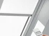 Witte VELUX Solar Plissé gordijn met bedieningsknoppen aan de zijkant