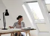 Mann en kind in een woonkamer met een open VELUX raam en gordijn
